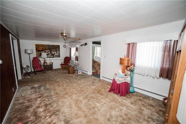 interior space featuring plenty of natural light, carpet flooring, ceiling fan, and a baseboard radiator