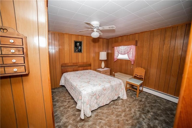 carpeted bedroom featuring wood walls, a baseboard radiator, and ceiling fan