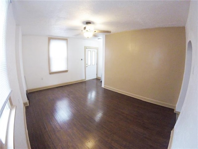 unfurnished room featuring ceiling fan, a textured ceiling, and dark hardwood / wood-style floors