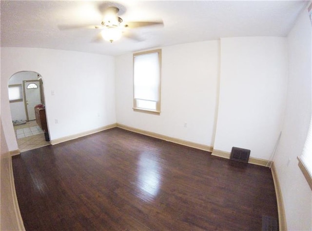 empty room with ceiling fan, a textured ceiling, and dark hardwood / wood-style flooring