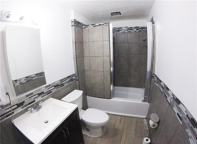 full bathroom with toilet, vanity, wood-type flooring, backsplash, and tile walls