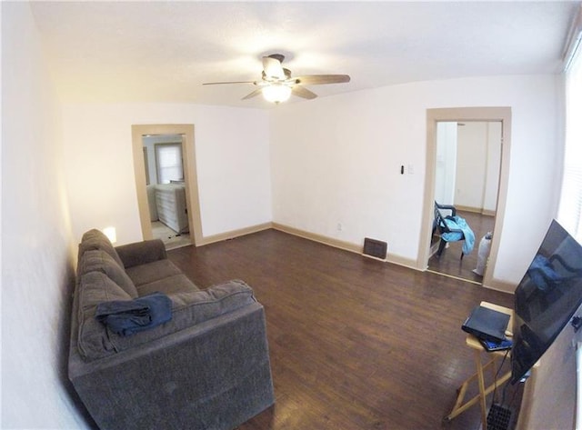 living room with ceiling fan and dark wood-type flooring