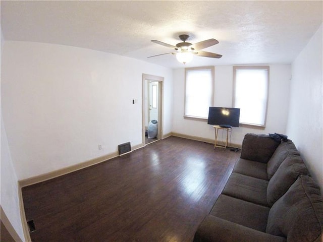 unfurnished living room featuring ceiling fan, dark wood-type flooring, and a textured ceiling