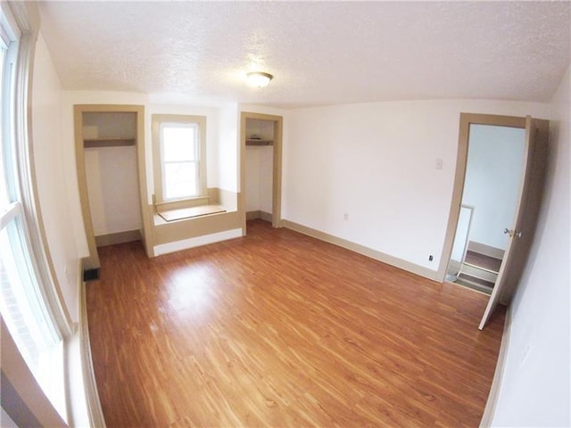 unfurnished bedroom with a textured ceiling and light hardwood / wood-style floors