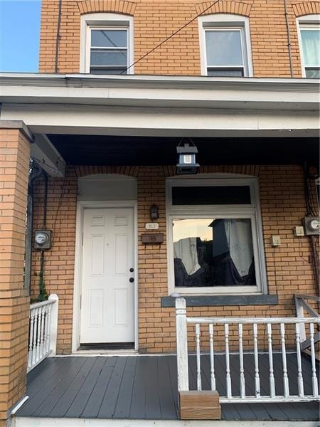 view of exterior entry with a porch