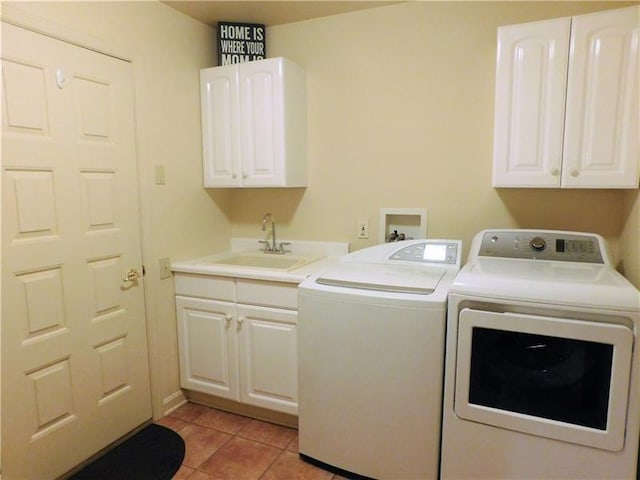 laundry room featuring cabinets, sink, light tile floors, washer hookup, and washing machine and clothes dryer