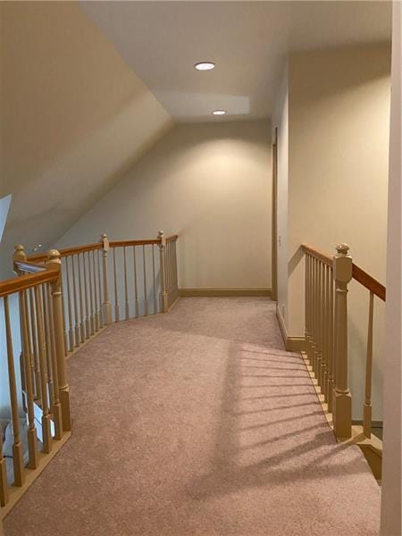 additional living space featuring light colored carpet and vaulted ceiling