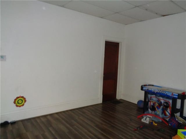 rec room with dark hardwood / wood-style floors and a paneled ceiling