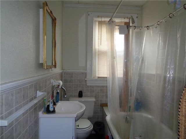 full bathroom with shower / bath combination with curtain, vanity with extensive cabinet space, toilet, and tile walls