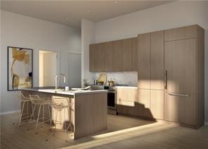 kitchen featuring a kitchen bar, light hardwood / wood-style floors, and a kitchen island with sink