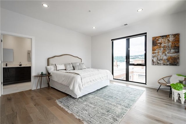 bedroom featuring light hardwood / wood-style flooring, access to exterior, and ensuite bathroom