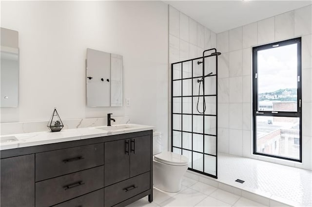 bathroom with double sink, a tile shower, tile floors, toilet, and oversized vanity