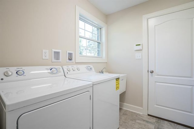 laundry area featuring washer and dryer and light tile floors