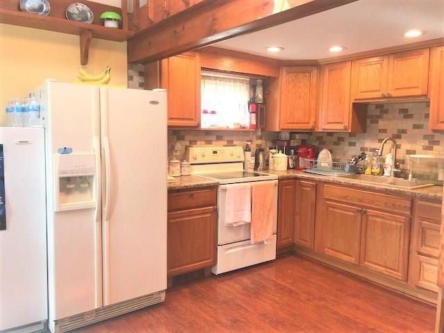 kitchen featuring white appliances, backsplash, dark hardwood / wood-style floors, and sink