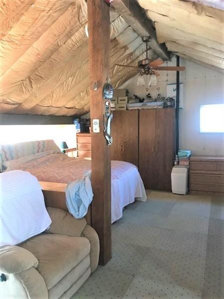 carpeted bedroom featuring ceiling fan and lofted ceiling with beams