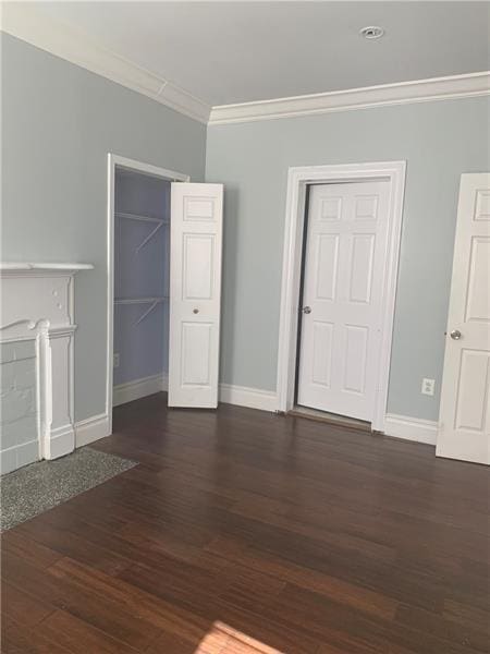 spare room featuring crown molding and dark hardwood / wood-style floors