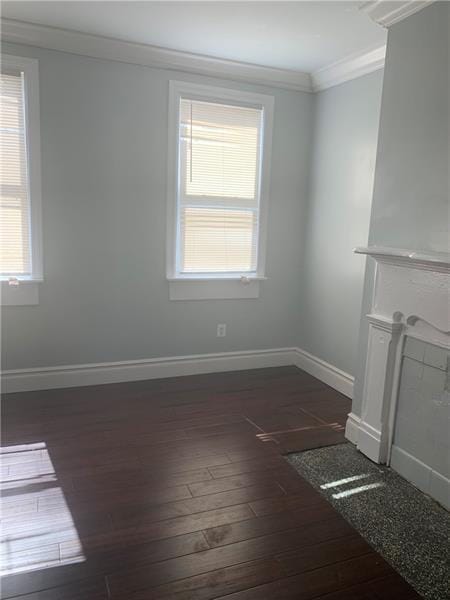 unfurnished living room with plenty of natural light, dark hardwood / wood-style flooring, and ornamental molding