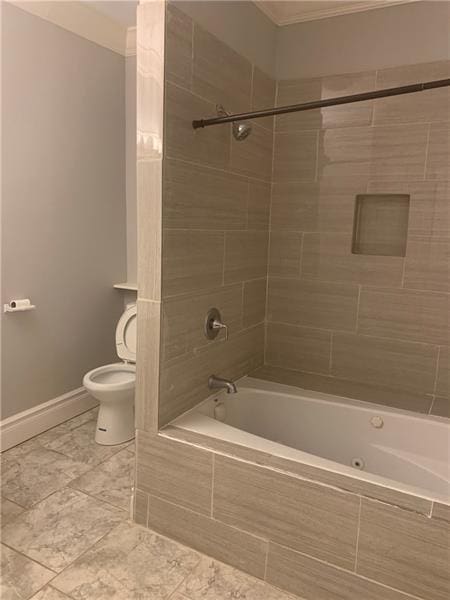 bathroom with tiled shower / bath combo, tile floors, crown molding, and toilet