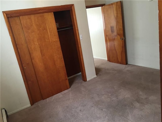 unfurnished bedroom featuring a closet and light carpet