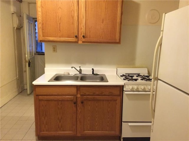 kitchen with light tile flooring, white appliances, and sink