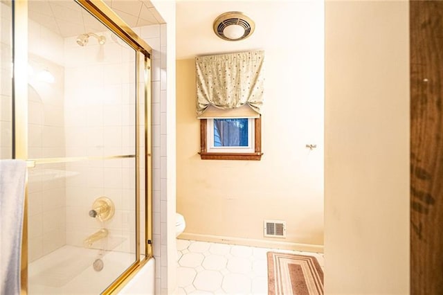 bathroom with toilet and combined bath / shower with glass door