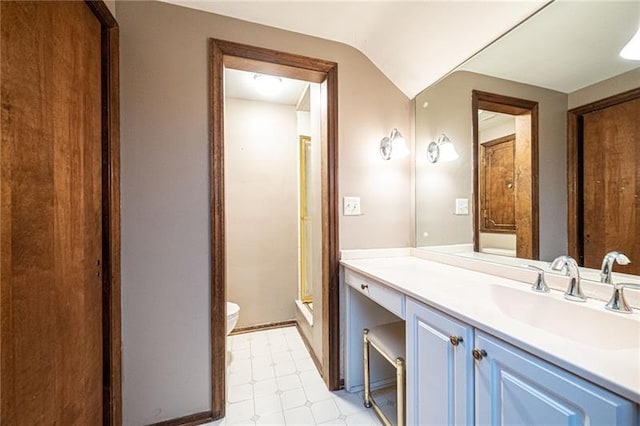 bathroom featuring toilet, vanity, lofted ceiling, and tile flooring