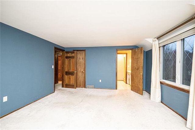 unfurnished bedroom featuring light carpet