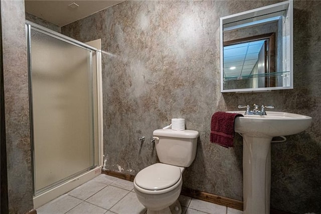 bathroom featuring a shower with door, tile floors, and toilet