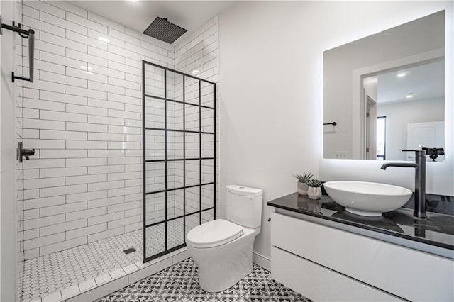 bathroom featuring vanity, tile floors, toilet, and walk in shower