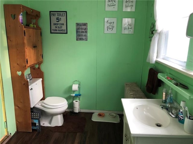 bathroom with radiator heating unit, vanity, toilet, and hardwood / wood-style flooring