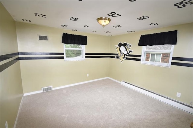 carpeted empty room with a baseboard heating unit