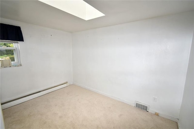 empty room with light colored carpet, a skylight, and baseboard heating