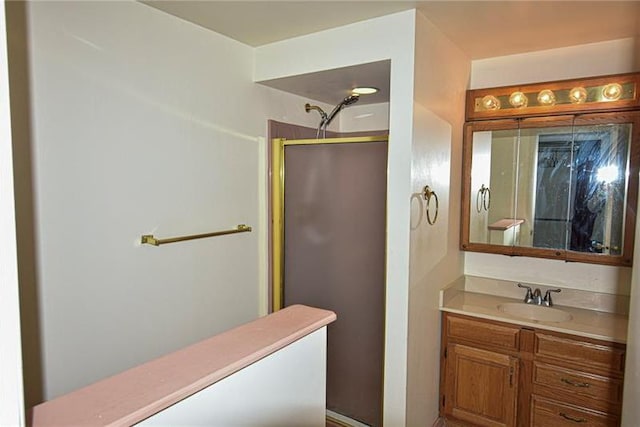 bathroom featuring walk in shower and vanity