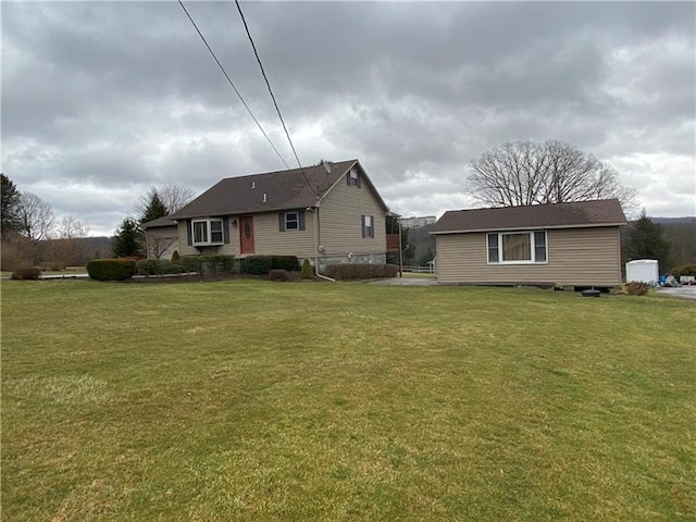 back of property with an outdoor structure and a yard