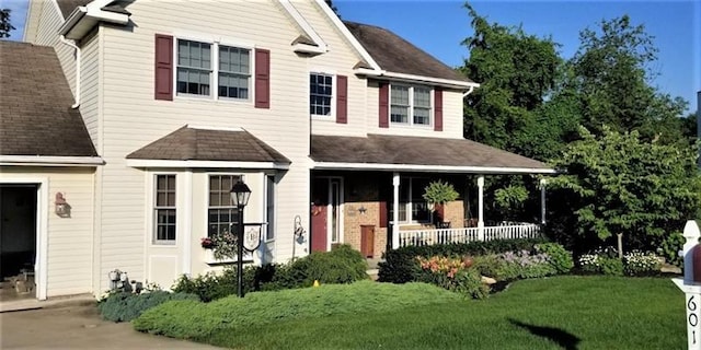 view of front of property with covered porch and a front lawn