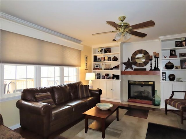 living room featuring built in features, ceiling fan, and ornamental molding