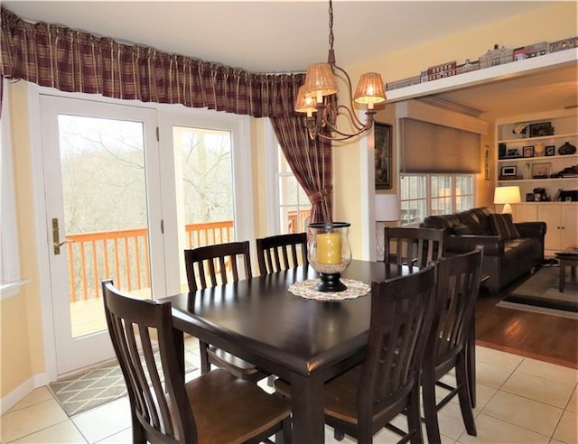 dining area with built in shelves, light tile floors, and an inviting chandelier