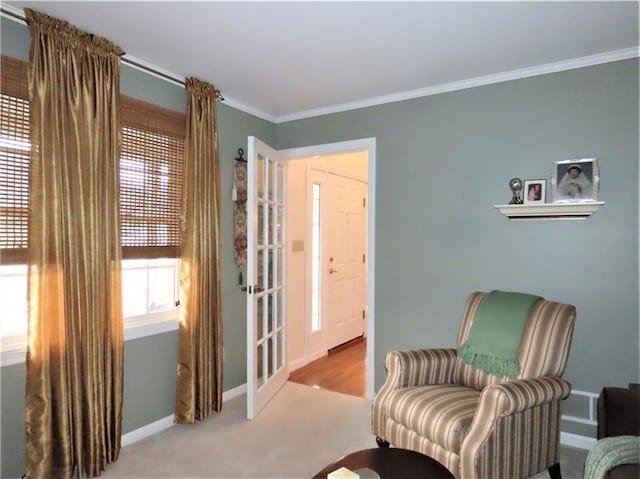 living area with ornamental molding and light colored carpet