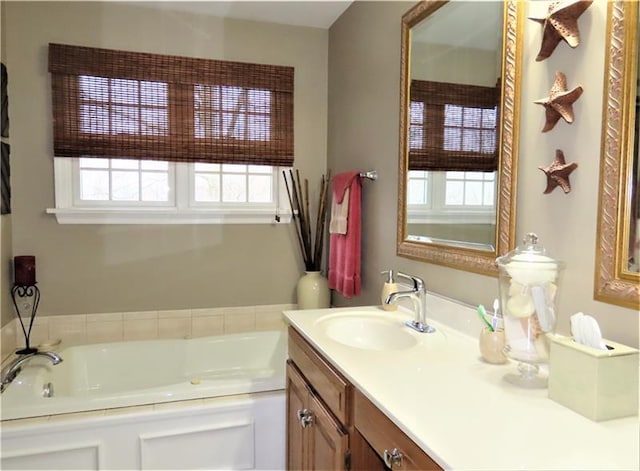 bathroom with a tub, a wealth of natural light, and oversized vanity