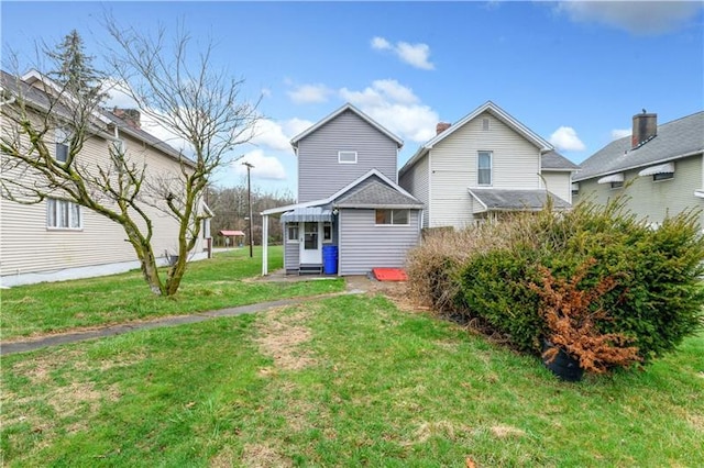 rear view of property with a lawn