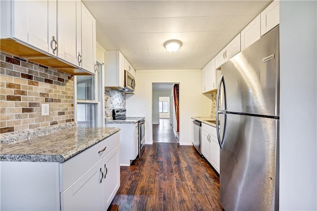 kitchen with tasteful backsplash, dark wood-type flooring, appliances with stainless steel finishes, and white cabinetry