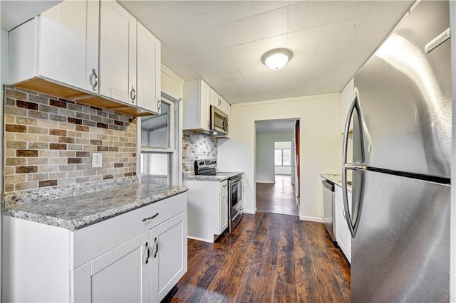 kitchen with white cabinets, tasteful backsplash, stainless steel appliances, and dark hardwood / wood-style flooring