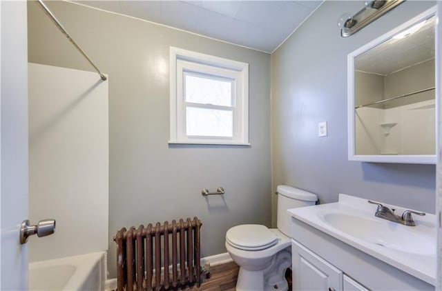 full bathroom with bathtub / shower combination, wood-type flooring, radiator, toilet, and vanity with extensive cabinet space