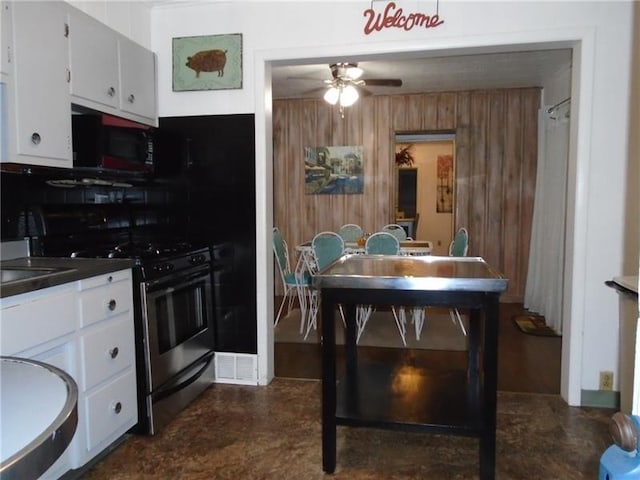 kitchen featuring ceiling fan, stainless steel range oven, and white cabinets