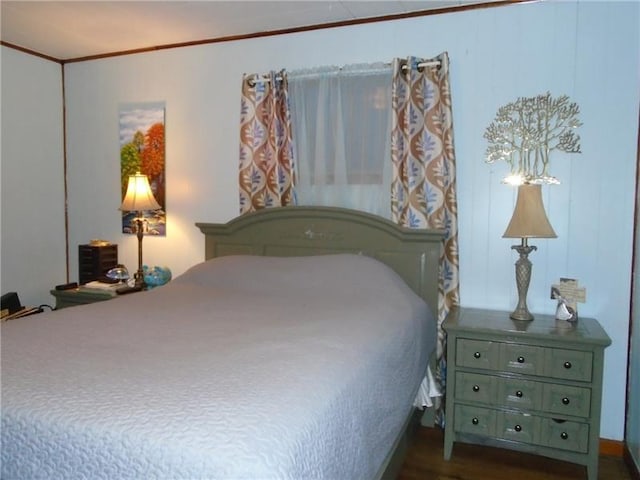 bedroom with dark hardwood / wood-style flooring and ornamental molding