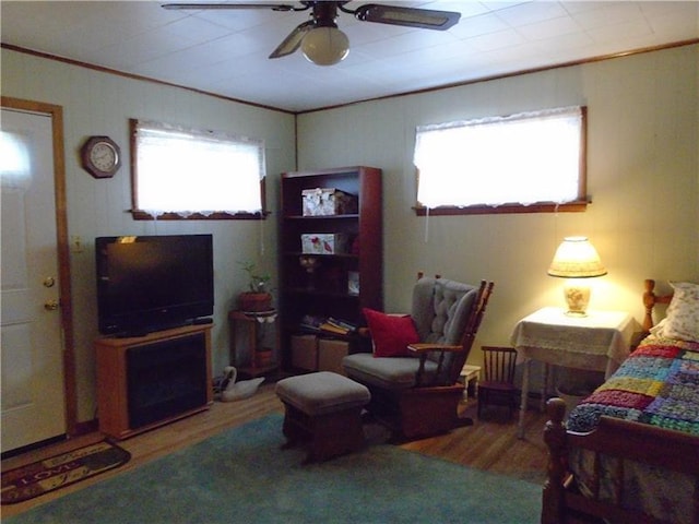 bedroom featuring hardwood / wood-style floors, multiple windows, crown molding, and ceiling fan