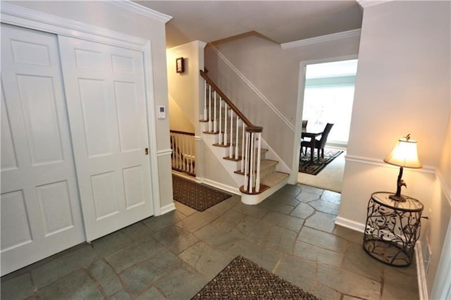 entryway featuring crown molding and dark tile flooring