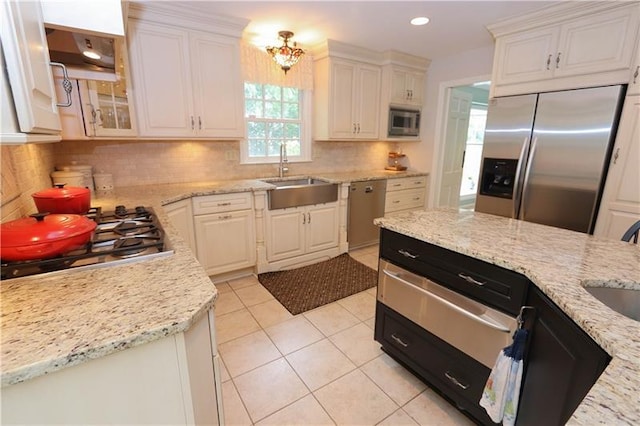 kitchen with light stone countertops, backsplash, sink, and stainless steel appliances