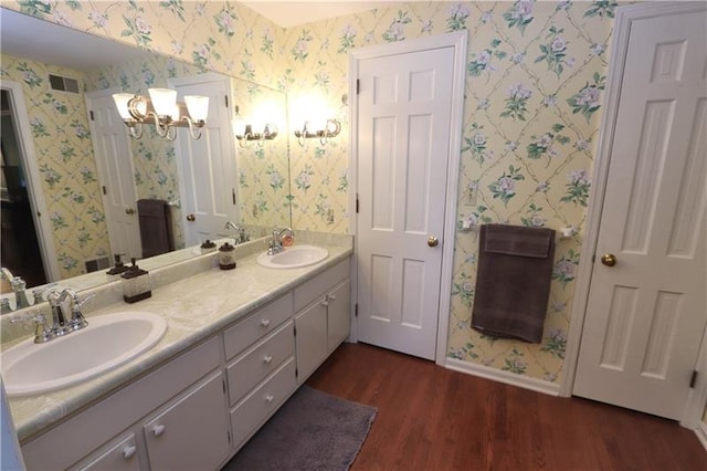 bathroom featuring double sink vanity, a notable chandelier, and hardwood / wood-style flooring