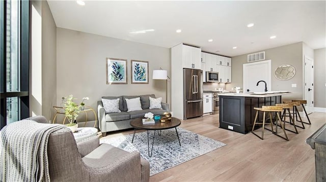 living room featuring sink and light wood-type flooring